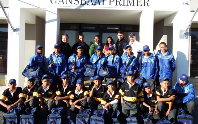 Die trotse o/13A rugbyspan van Gansbaai PrimÃªr met hul volledige uitrustings, met agter vlnr Dirkie Kotze, Steyn Miller, Tommy Volkwyn, Natassia Valentine, JP Coetzer en Stephen Ashlin, met afrigter Hilton Temmers regs in die 2de ry 